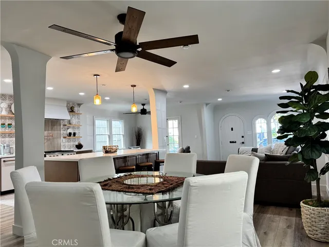 a large kitchen with stainless steel appliances a stove a sink dishwasher and a dining table with the living room view