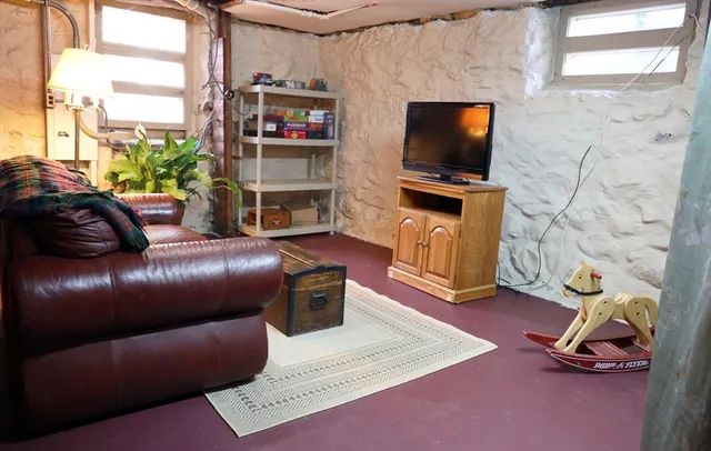 a living room with furniture a flat screen tv and a floor to ceiling window