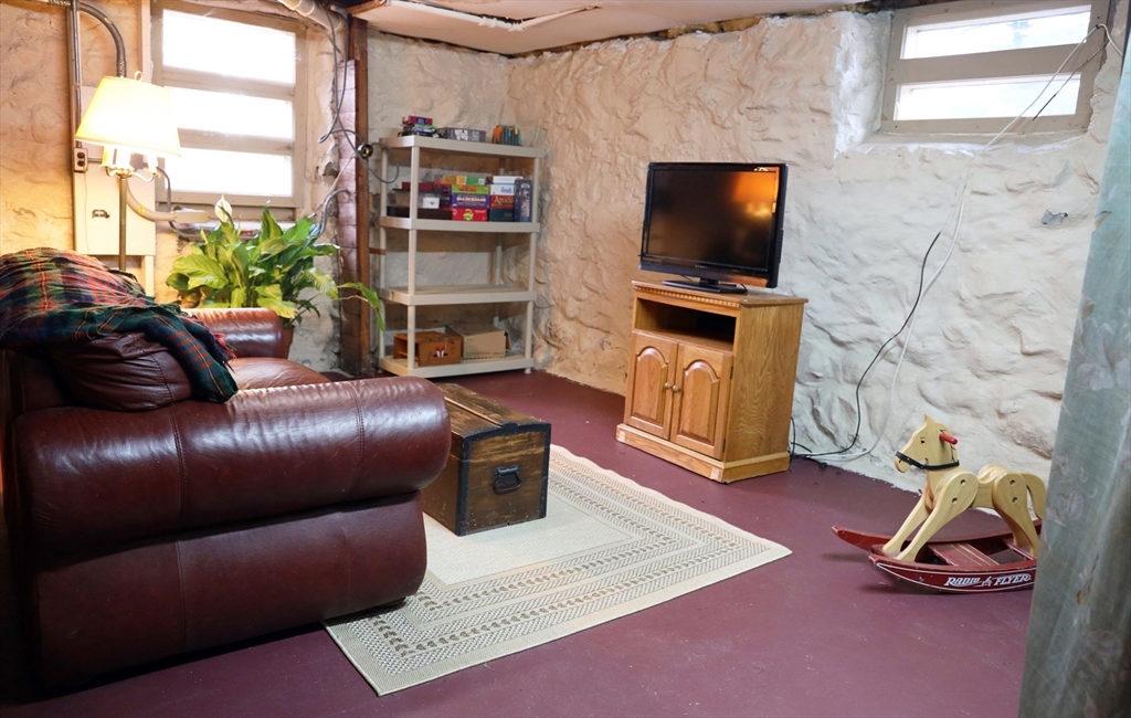 15 Beacon Street Danvers, MA 01923 - Photo 29 of 42 a living room with furniture a flat screen tv and a floor to ceiling window