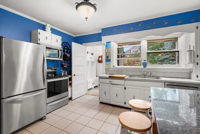 a kitchen with granite countertop a sink stainless steel appliances and window
