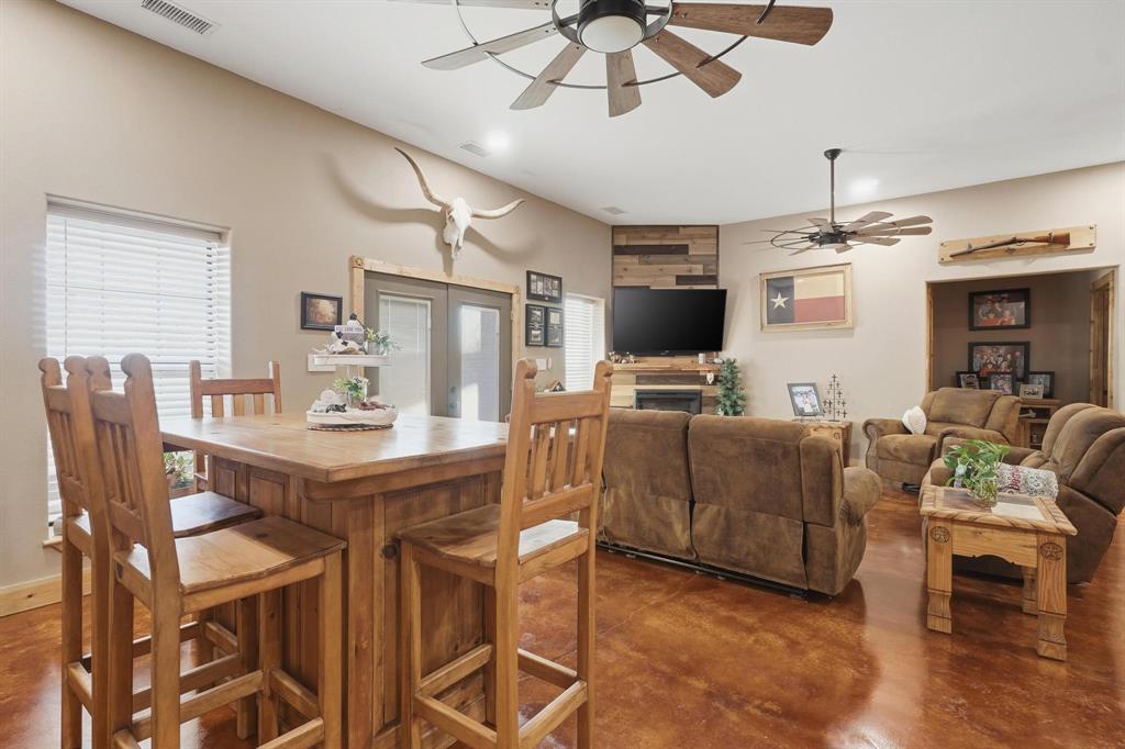 6499 Summerhill Road Abilene, TX 79601 - Photo 16 of 36 a living room with furniture a chandelier and a flat screen tv