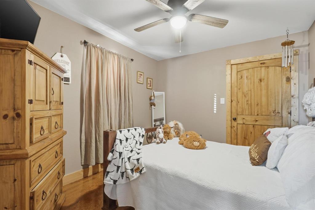 6499 Summerhill Road Abilene, TX 79601 - Photo 22 of 36 a bedroom with a bed and a chandelier