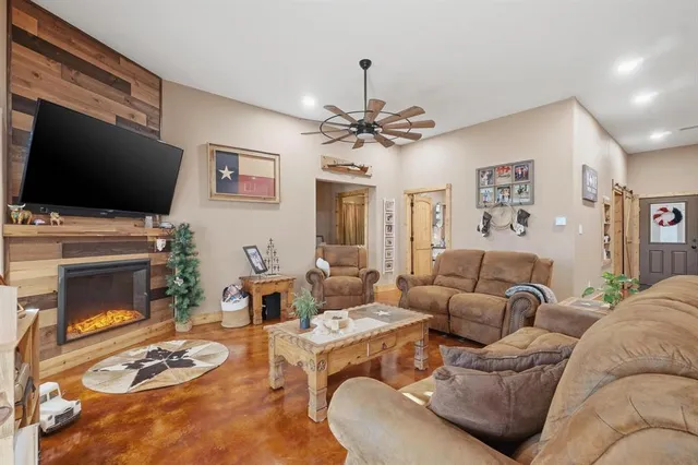 a living room with furniture kitchen view and a chandelier