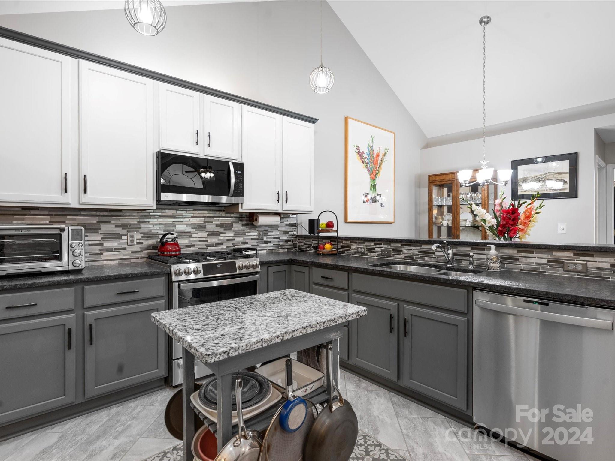 707 Ledgestone Court Fort Mill, SC 29708 - Photo 2 of 40 a kitchen with kitchen island a stove a sink a microwave a dining table and chairs