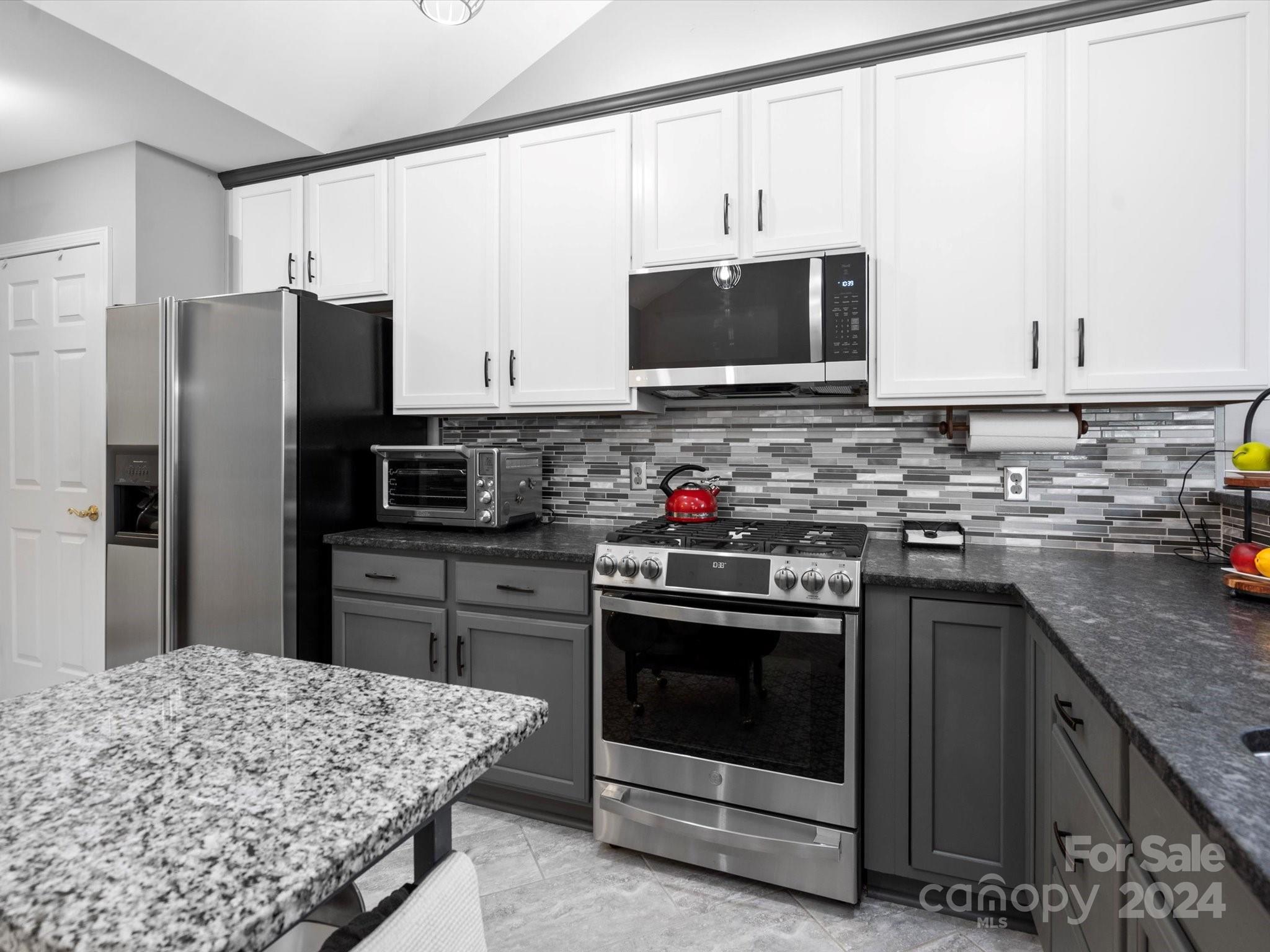 707 Ledgestone Court Fort Mill, SC 29708 - Photo 3 of 40 a kitchen with granite countertop cabinets stainless steel appliances and a counter space