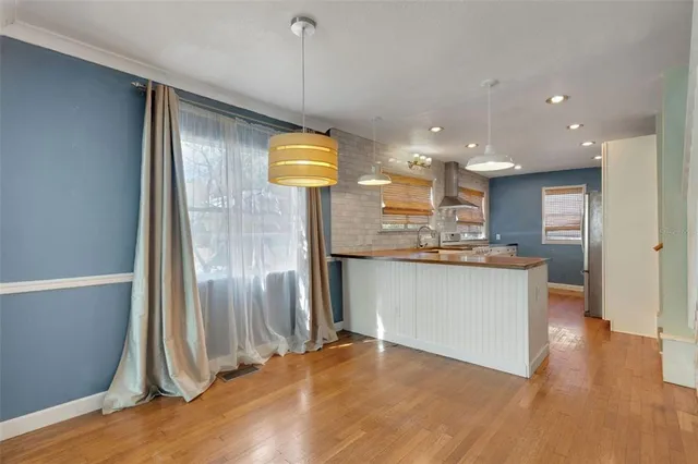 a kitchen with stainless steel appliances granite countertop a refrigerator a sink and a stove