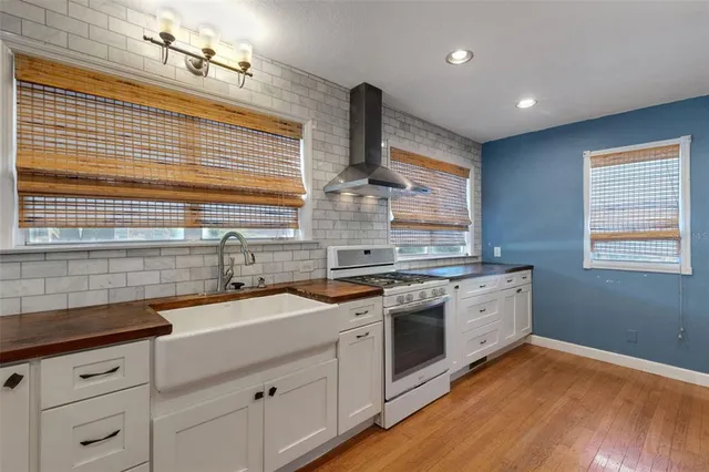 an empty room with chandelier fan and windows
