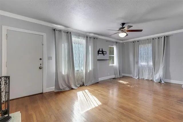 a view of a room with wooden floor and windows