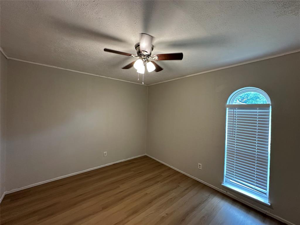 5908 Maple Lane Rowlett, TX 75089 - Photo 11 of 25 an empty room with wooden floor chandelier fan and windows