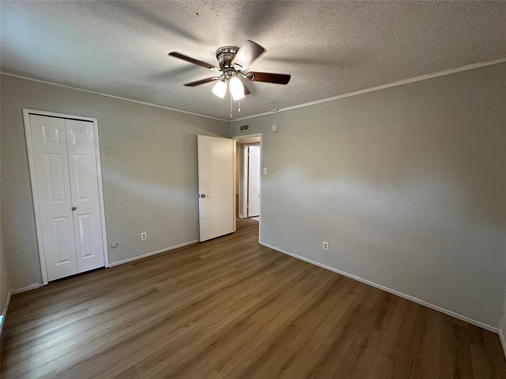 5908 Maple Lane Rowlett, TX 75089 - Photo 13 of 25 an empty room with wooden floor fan and windows