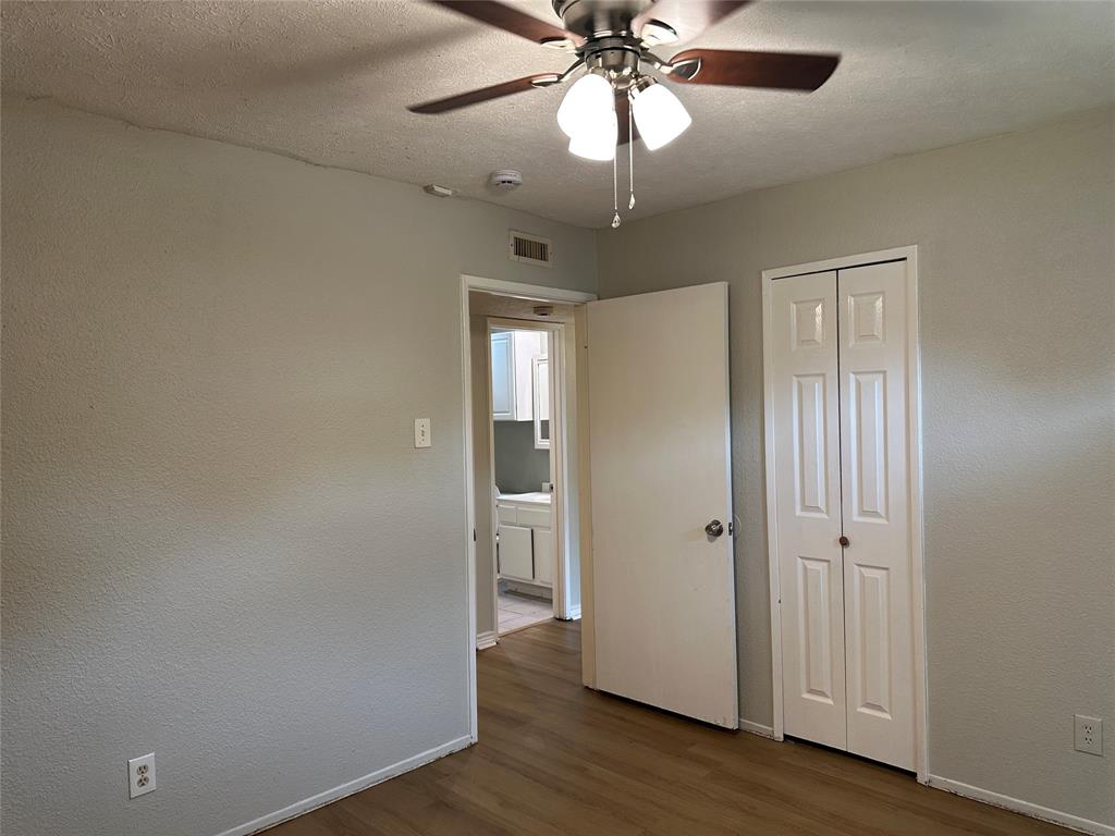 5908 Maple Lane Rowlett, TX 75089 - Photo 15 of 25 an empty room with wooden floor closet and windows