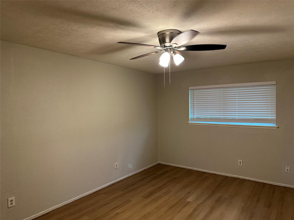 5908 Maple Lane Rowlett, TX 75089 - Photo 17 of 25 an empty room with wooden floor fan and windows