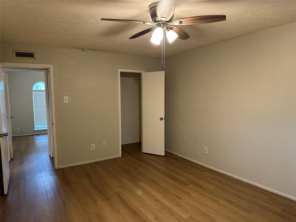 5908 Maple Lane Rowlett, TX 75089 - Photo 18 of 25 an empty room with wooden floor fan and windows