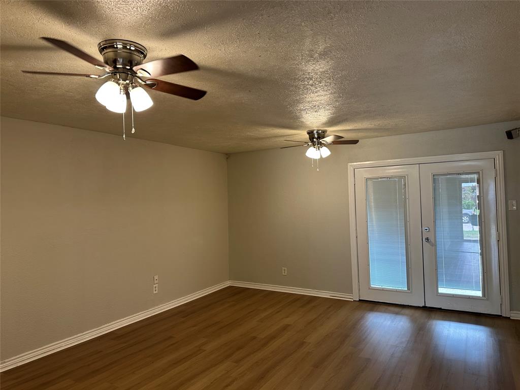 5908 Maple Lane Rowlett, TX 75089 - Photo 3 of 25 a view of an empty room with wooden floor and a ceiling fan