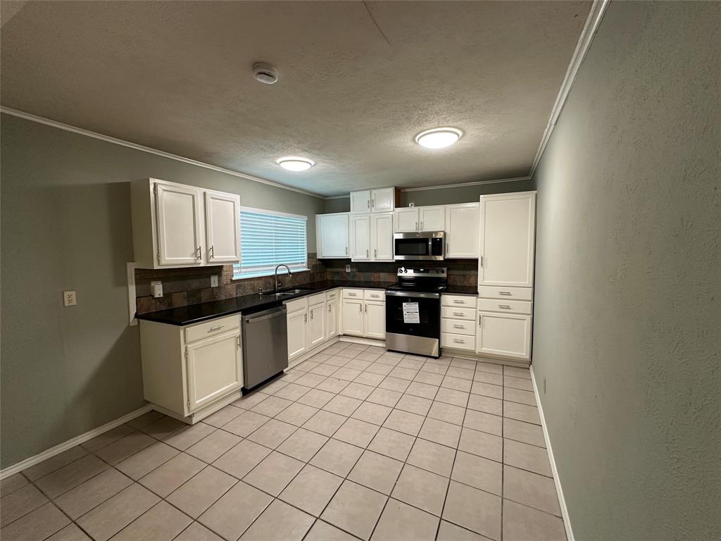 5908 Maple Lane Rowlett, TX 75089 - Photo 6 of 25 a kitchen with stainless steel appliances granite countertop a stove a sink and a refrigerator