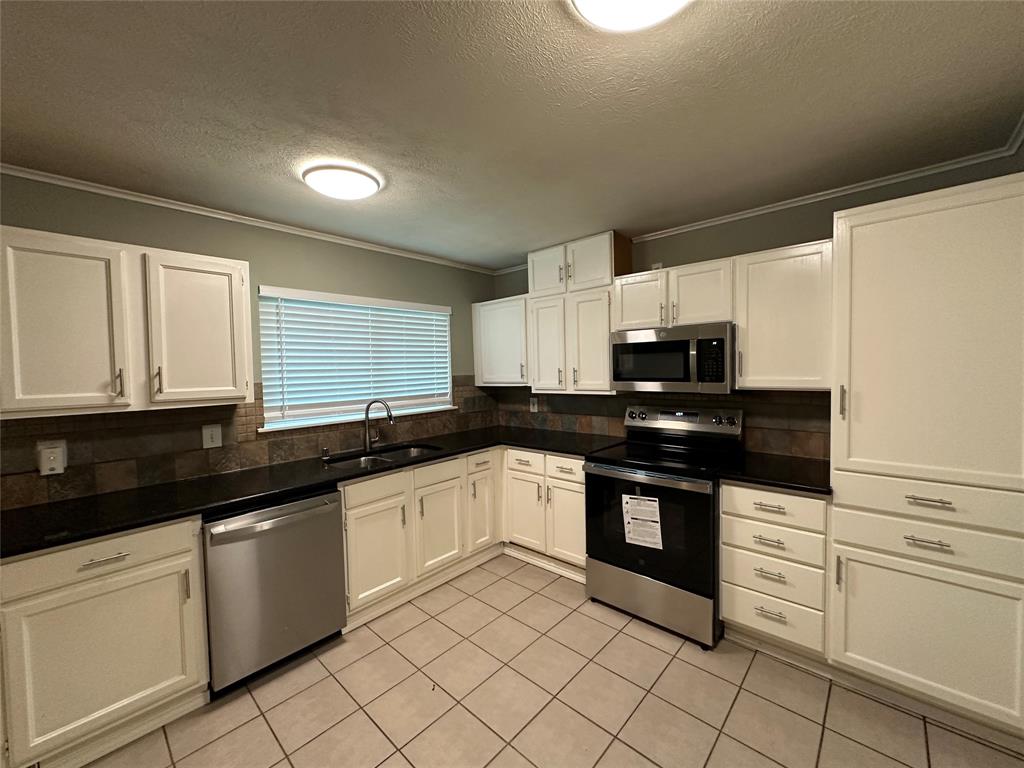 5908 Maple Lane Rowlett, TX 75089 - Photo 8 of 25 a kitchen with stainless steel appliances granite countertop a sink and cabinets