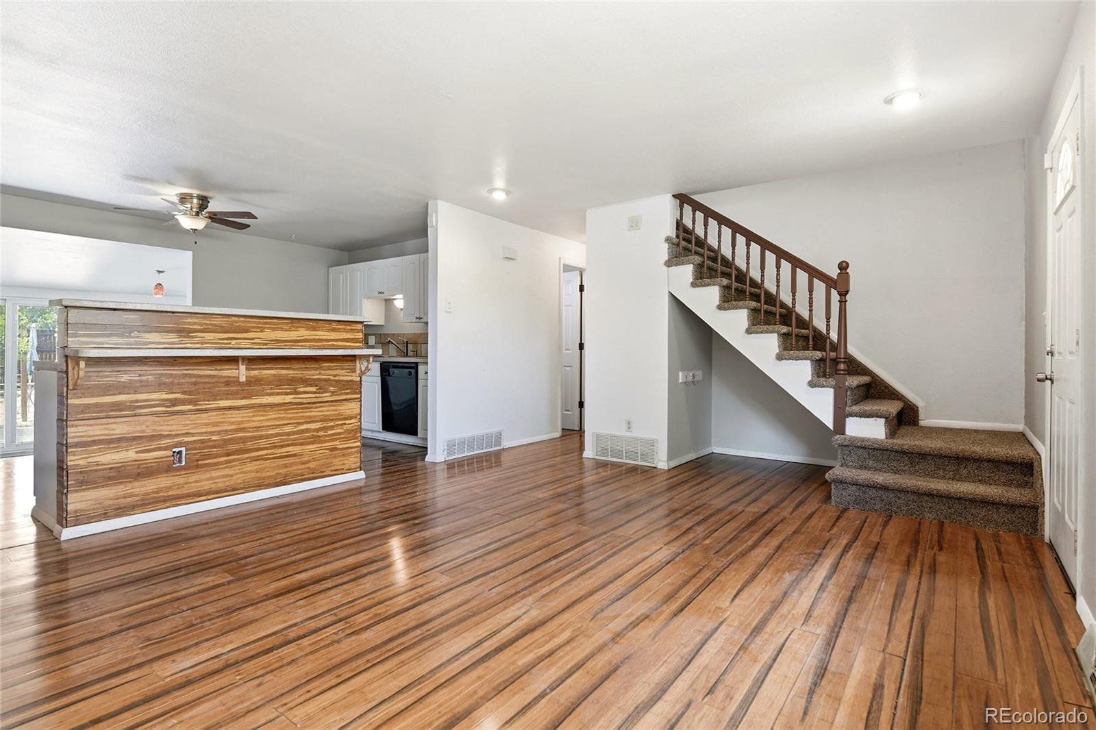 7461 Webster Street Arvada, CO 80003 - Photo 12 of 31 a view of hallway with wooden floor and stairs