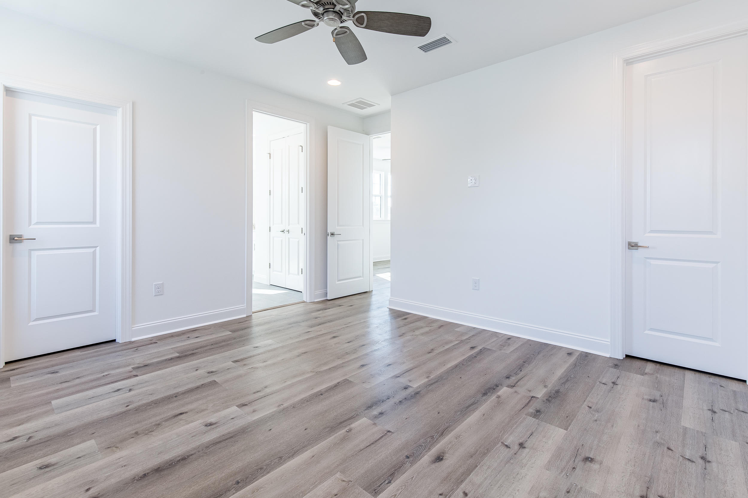 129 Windrow Way, Unit LOT 252 Watersound, FL 32461 - Photo 20 of 38 an empty room with wooden floor ceiling fan and windows