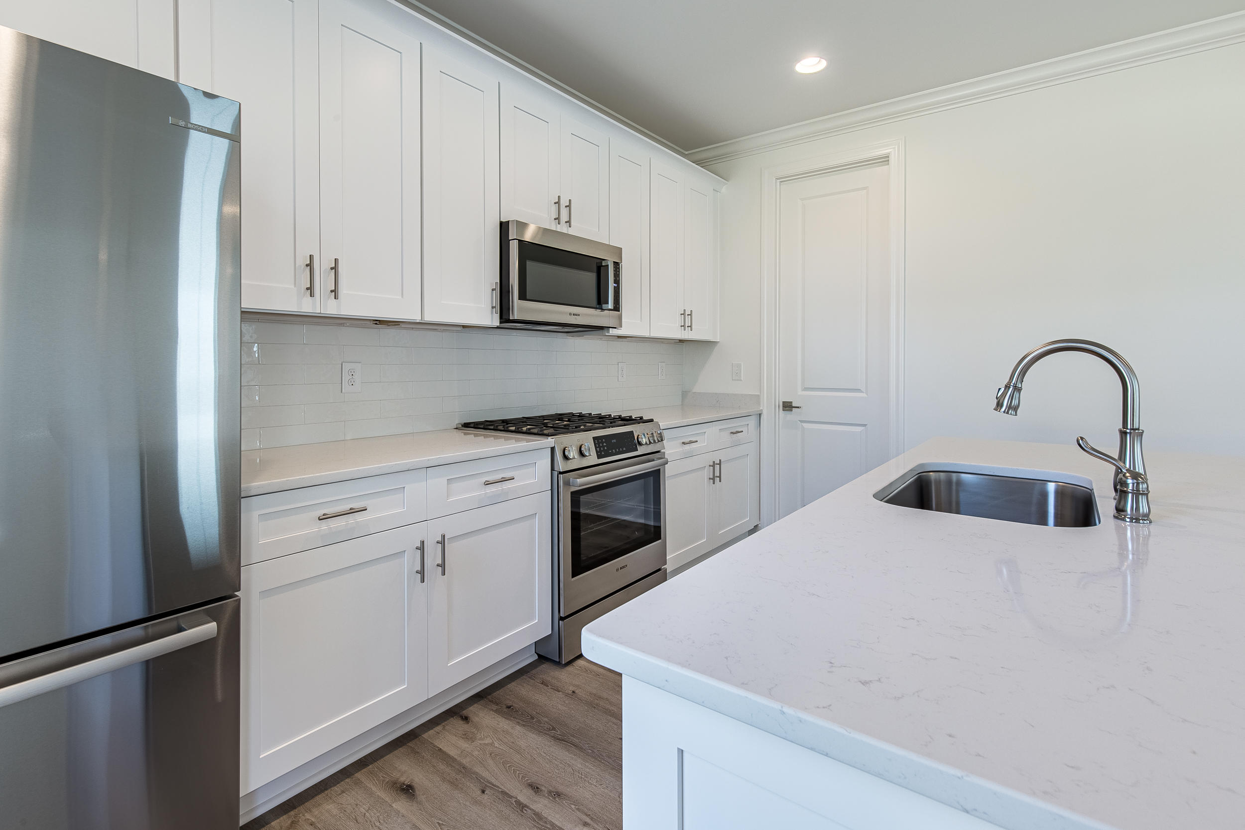 129 Windrow Way, Unit LOT 252 Watersound, FL 32461 - Photo 5 of 38 a kitchen with white cabinets and stainless steel appliances