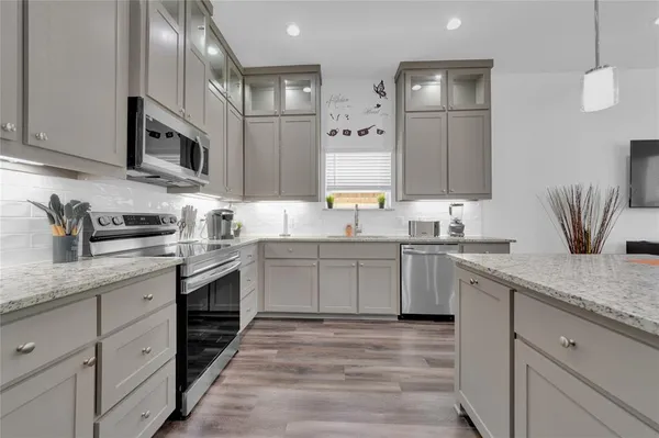 a kitchen with cabinets stainless steel appliances and a counter space