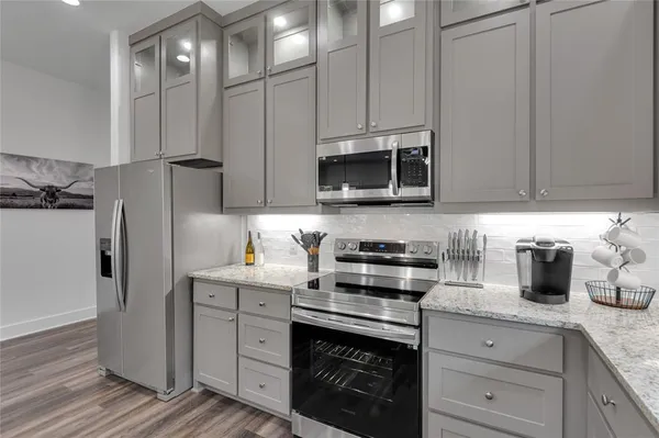 a large kitchen with stainless steel appliances granite countertop a sink refrigerator and cabinets