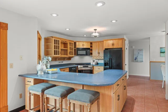 a kitchen with stainless steel appliances a dining table chairs and wooden floor