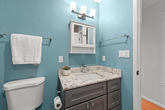 a bathroom with a sink a toilet and mirror
