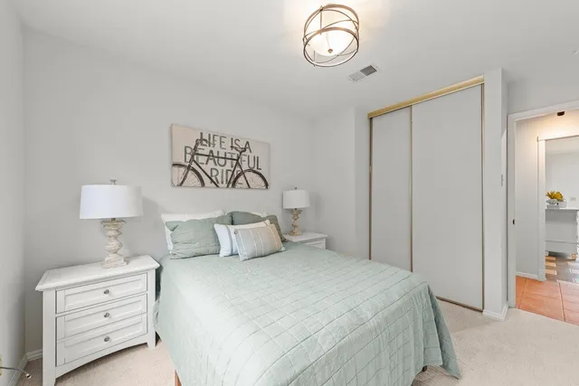 a bedroom with a bed and a lamp on dresser