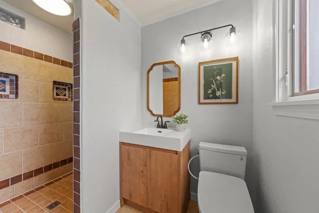 a bathroom with a toilet sink and mirror