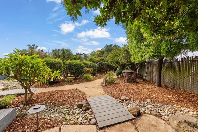 a view of a patio with table and chairs and wooden fence