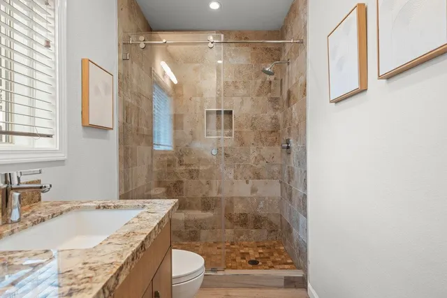 a bathroom with a shower a mirror and a sink