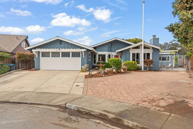 a front view of a house with a yard and potted plants