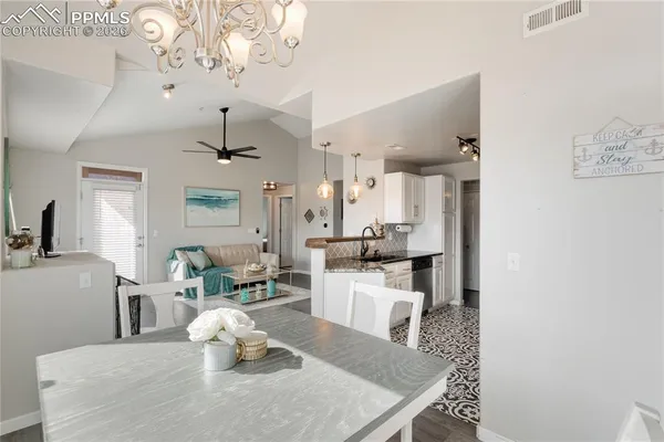 a living room with kitchen island furniture and a chandelier