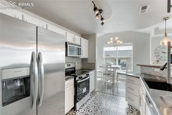 a kitchen with a refrigerator a sink a stove and cabinets