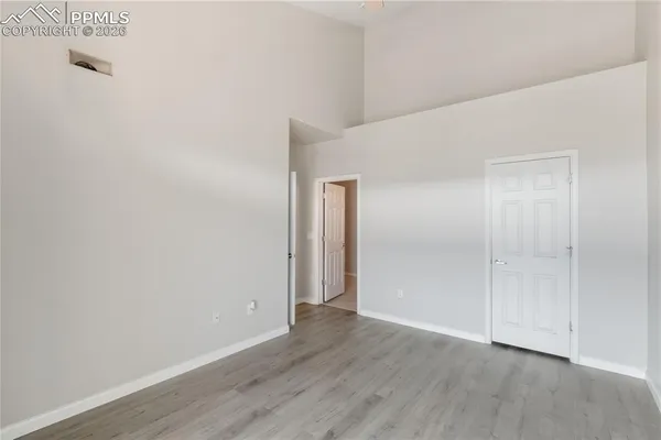 a view of an empty room with wooden floor