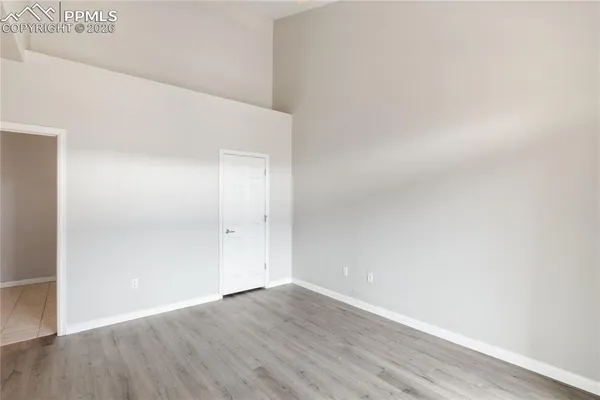 a view of an empty room with wooden floor
