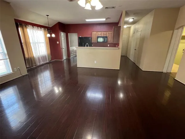 a view of a living room and kitchen with wooden floor