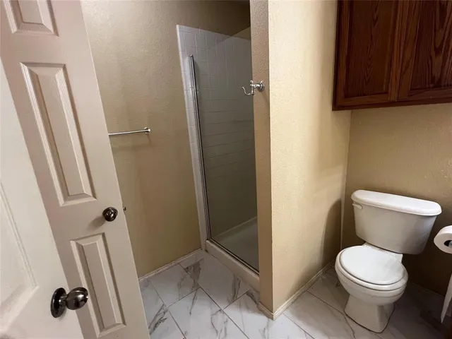 a bathroom with a toilet and a shower