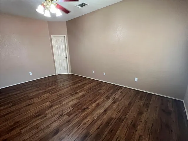a view of an empty room with a chandelier fan