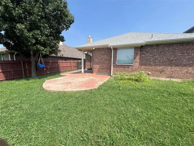 a backyard of a house with table and chairs