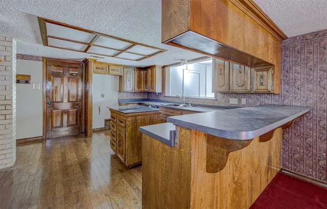 a kitchen that has a kitchen island wooden floor and stainless steel appliances
