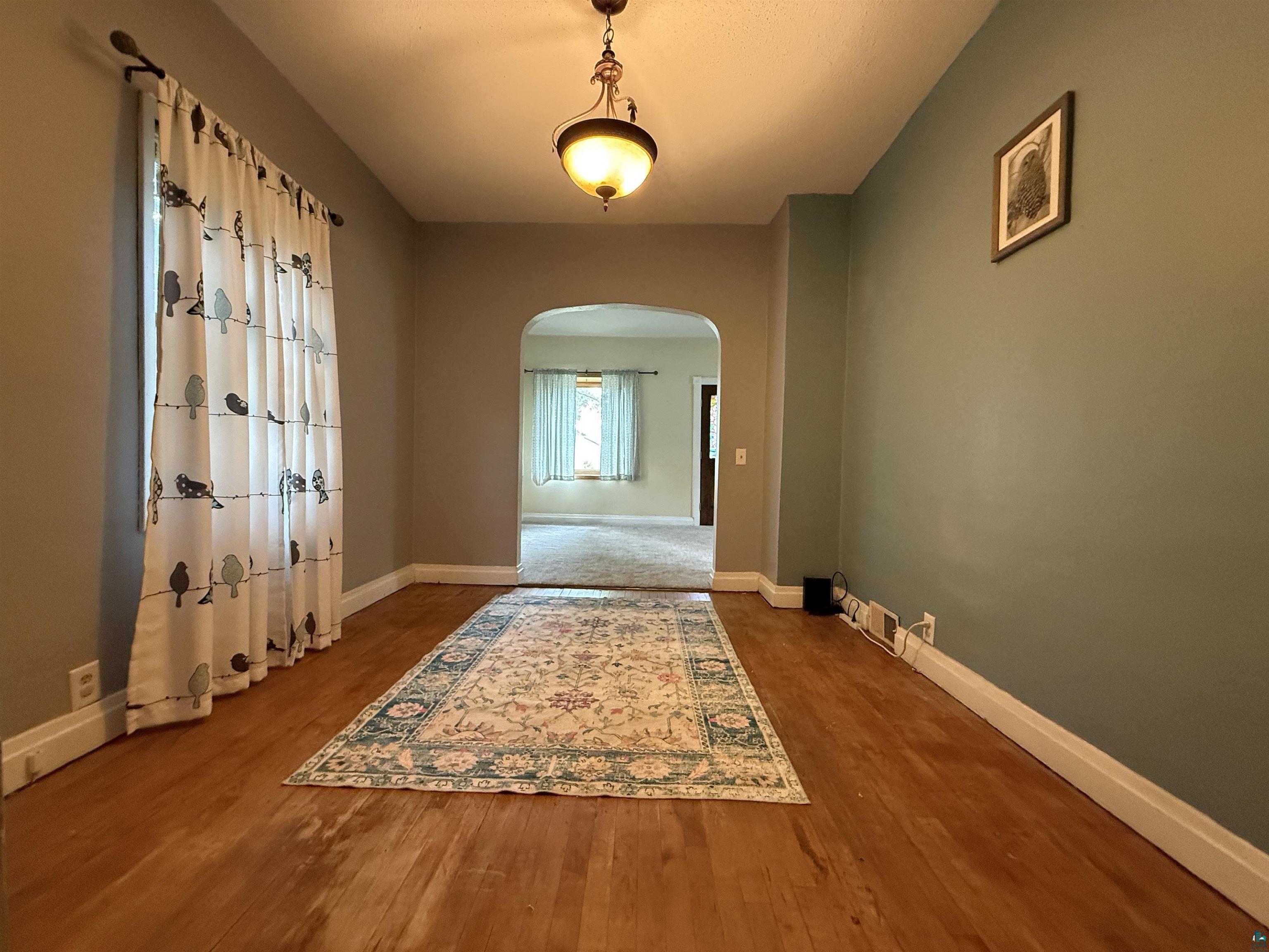 809 16th Street North Virginia, MN 55792 - Photo 17 of 44 Spare room with arched walkways and wood finished floors
