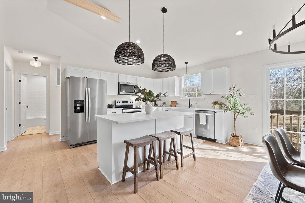 512 Cedar Hill Road Mineral, VA 23117 - Photo 11 of 53 a kitchen with stainless steel appliances kitchen island granite countertop a stove a sink a dining table and chairs with wooden floor