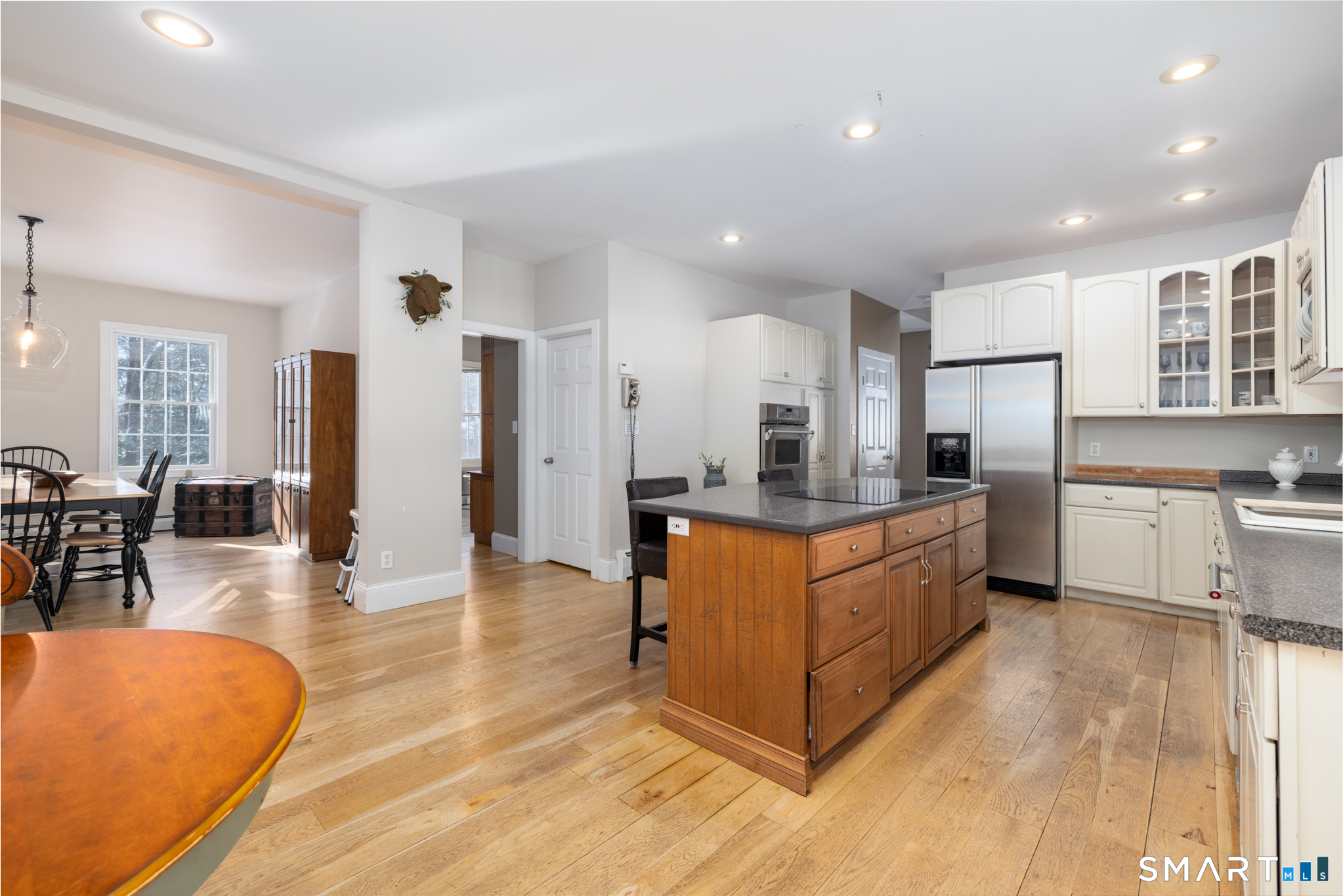 40 Warner Road Barkhamsted, CT 06063 - Photo 8 of 35 a large kitchen with stainless steel appliances granite countertop a refrigerator a stove a sink a dining table and chairs with wooden floor