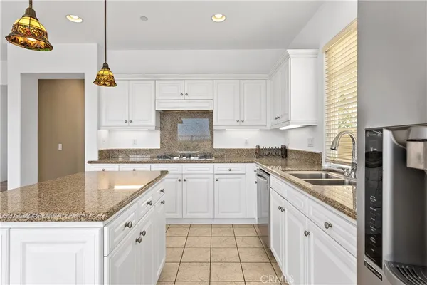 a kitchen with white cabinets and a refrigerator