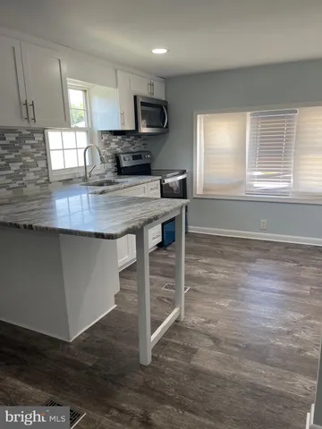 a kitchen with kitchen island a sink appliances and a counter top space