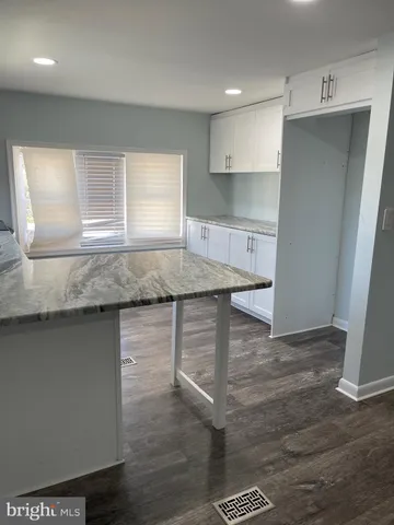 a kitchen with kitchen island a counter top a sink and cabinets