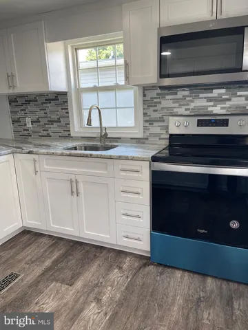 a kitchen with granite countertop a stove and a sink
