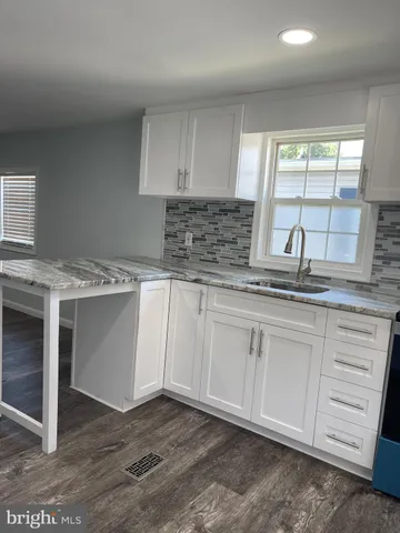a kitchen with granite countertop white cabinets and white appliances