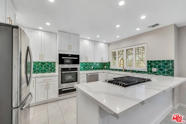 a kitchen with stainless steel appliances kitchen island a stove and a refrigerator